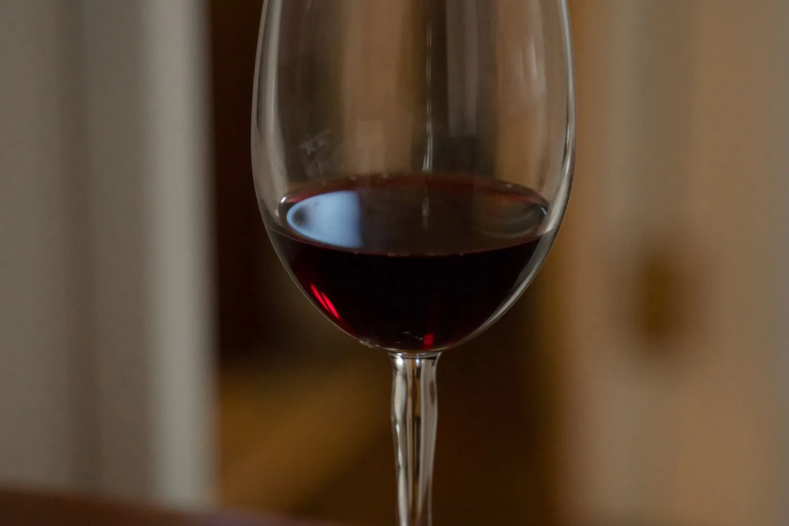 Close-up of a glass of red wine in warm, dim evening light.