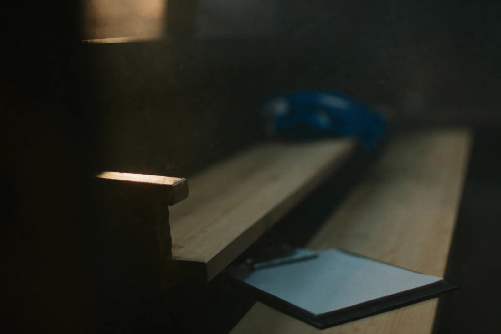Empty locker room bench with a clipboard in warm evening light.