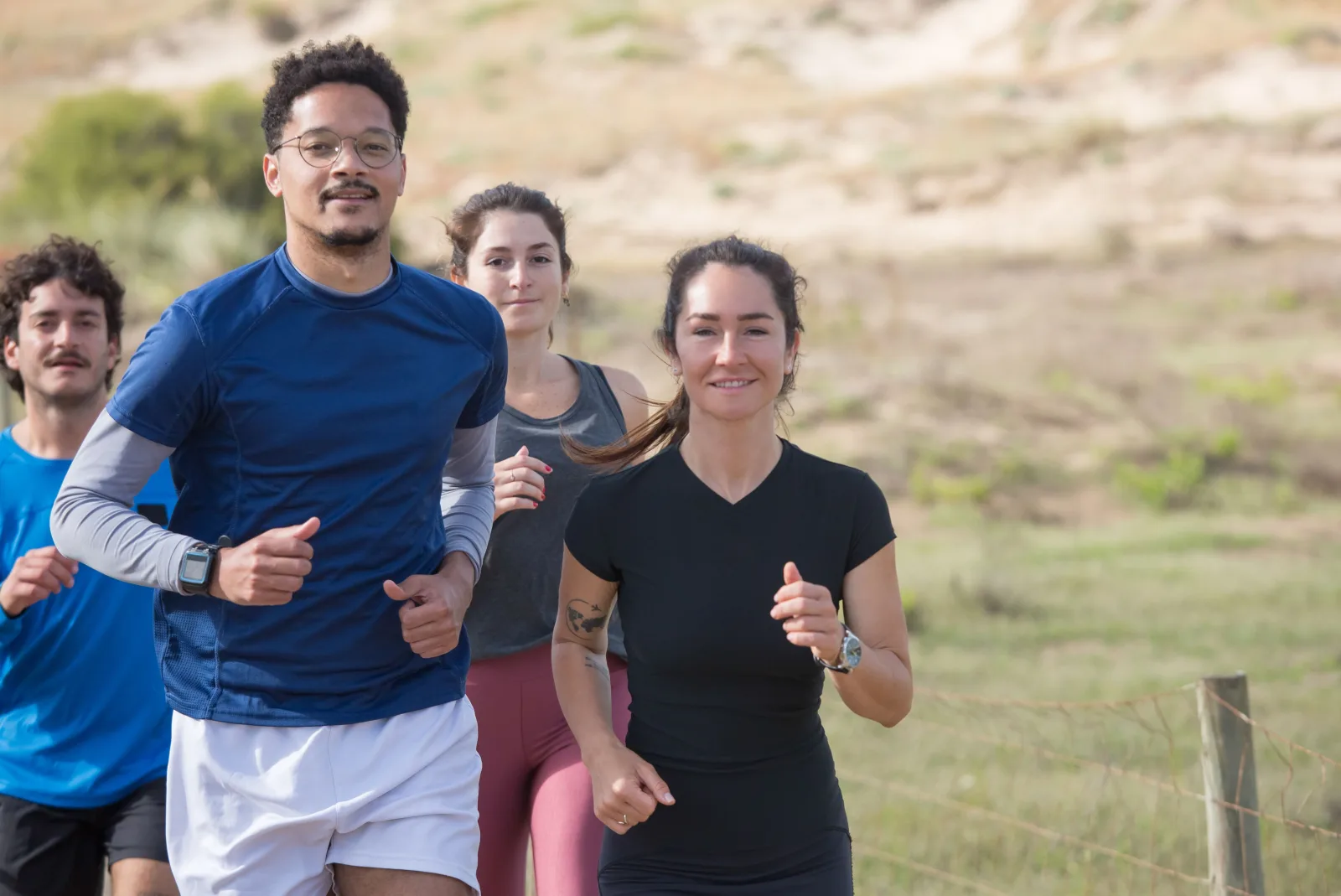 A diverse group runs together on a coastal path without a visible ranking.
