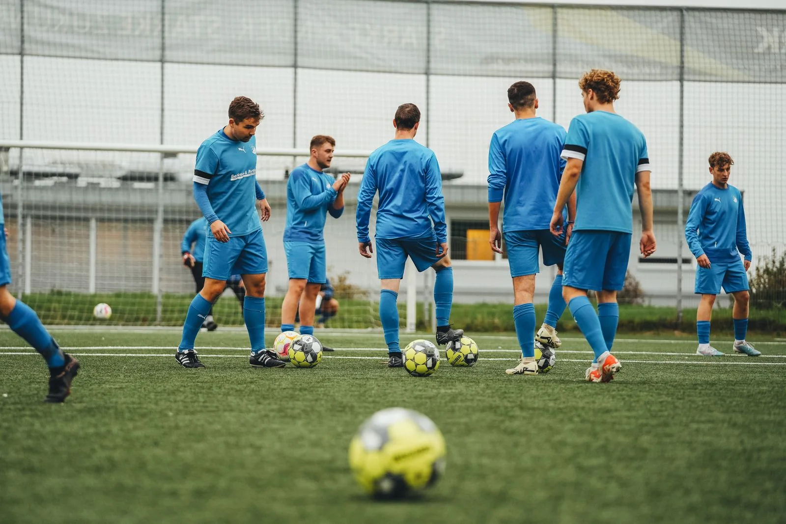 Footballer sprinting with the ball in training.