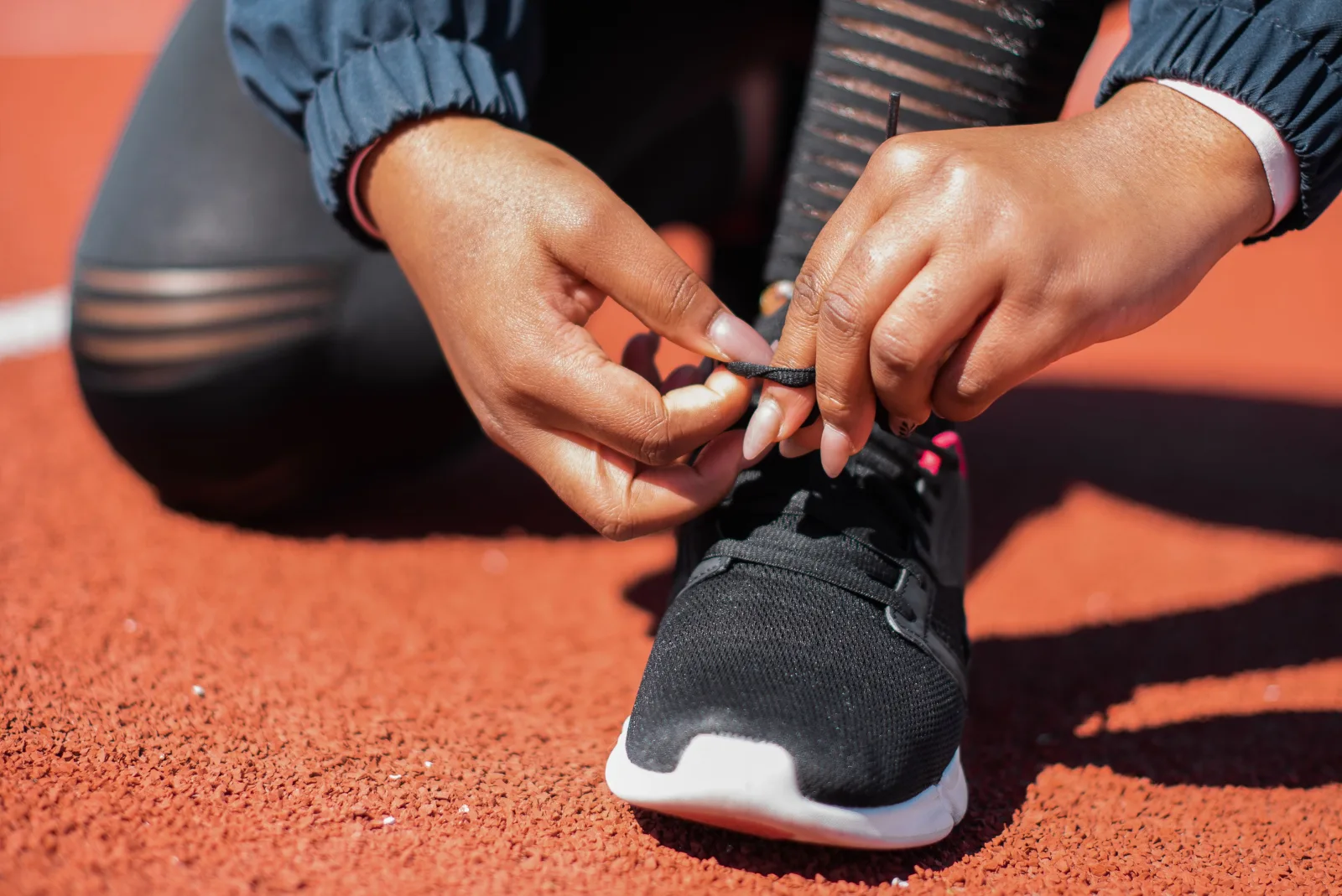 Runner ties his shoes before training while choosing between an intense session and an easy one.