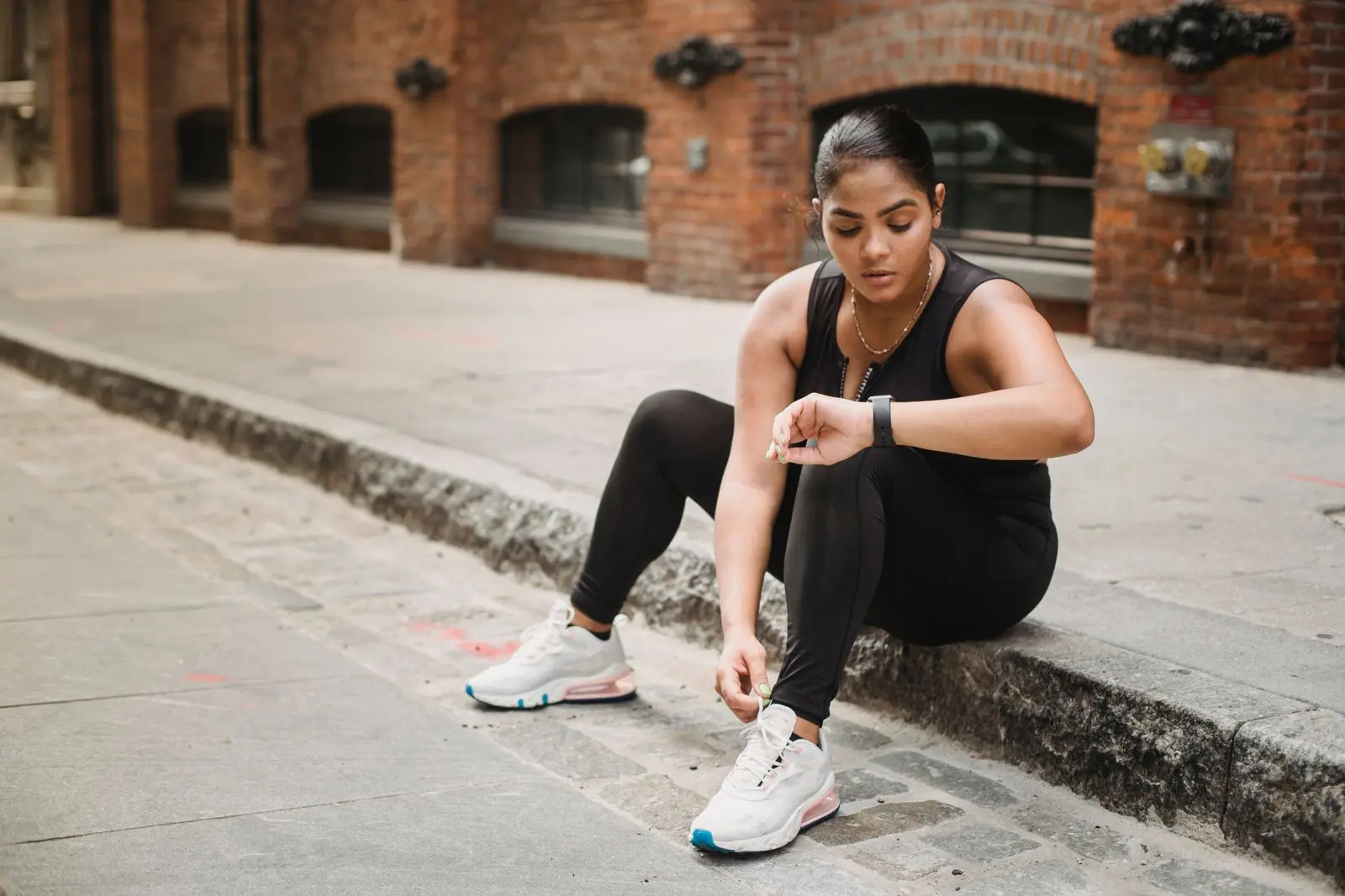 Woman in sportswear checking her smartwatch after a workout.