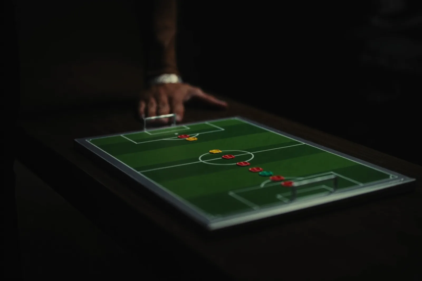 Soccer tactics board with magnets on a dark table in the locker room.