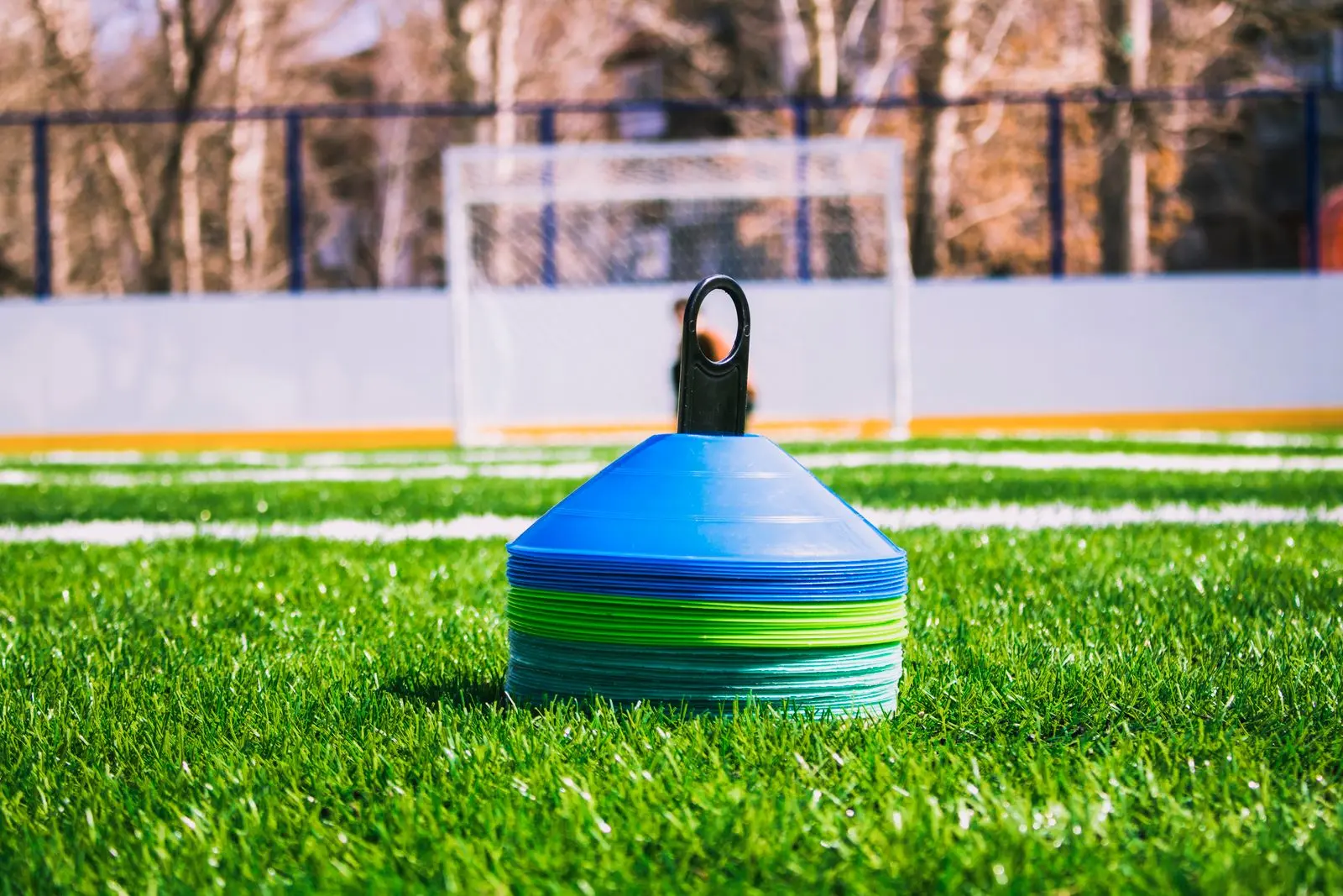 Stack of training cones on a football pitch in front of the goal.